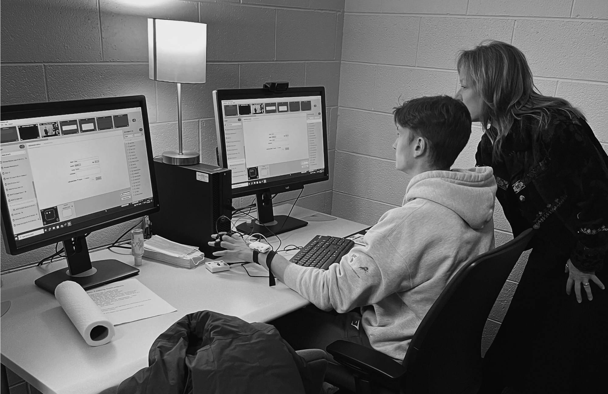 Student and professor in biometrics lab looking at computer. Image is in black and white